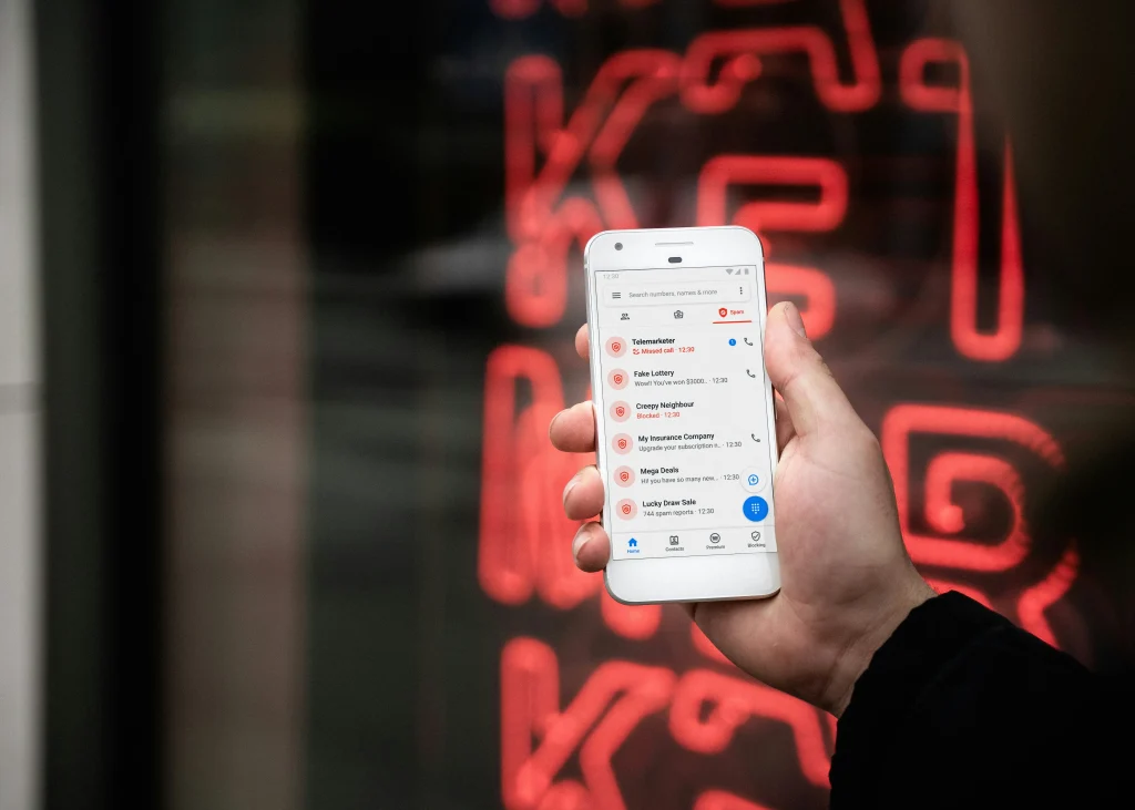 Hand holding smartphone showing spam calls highlighting the scam risks in industry and the need to research air duct cleaning pros and cons.
